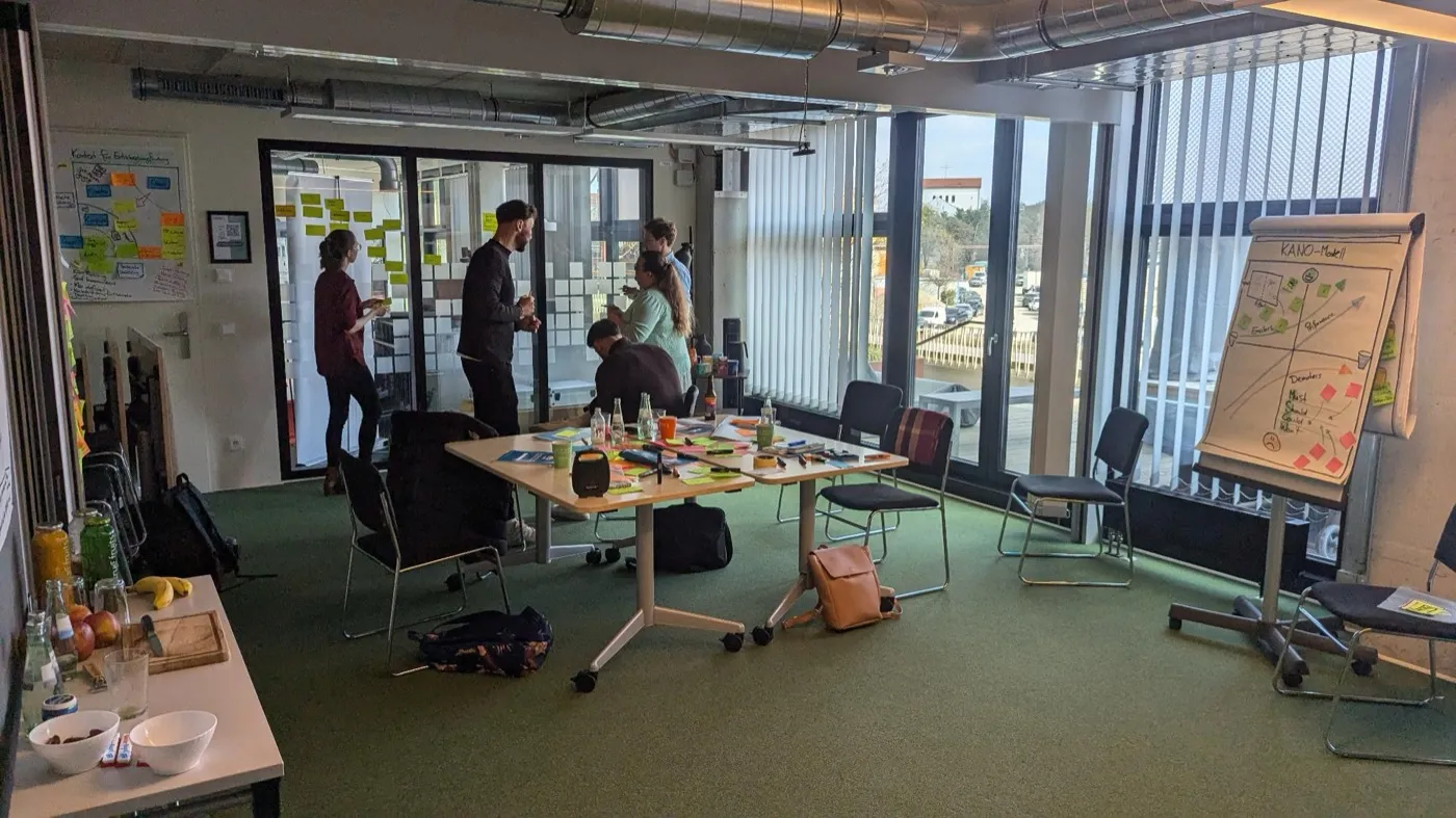 Teilnehmer:innen arbeiten im CSPO-Training in Kleingruppen an Story Maps und dem Kano-Modell